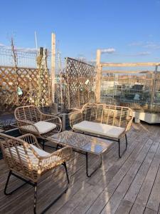 3 sillas y una mesa en una terraza con el océano en Charming studio shared rooftop terrace/Jacuzzi 360 view, en Budapest