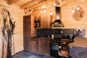 Romantikchalet في Vorra: مطبخ بجدران خشبية وموقد