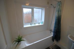 uma casa de banho branca com uma banheira e uma janela em Windsor 3 - Perfect Contractor Stay Free Parking 3 bedroom 4 beds Sleeps 6 em Gateshead