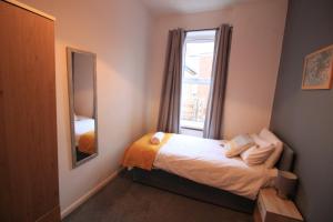 um pequeno quarto com uma cama e um espelho em Windsor 3 - Perfect Contractor Stay Free Parking 3 bedroom 4 beds Sleeps 6 em Gateshead