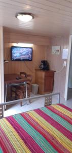 a small room with a table and a tv on the wall at Studio Wifi SdB à l'italienne in Chauffailles