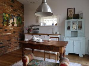 a kitchen with a wooden table and a brick wall at Namas senamiestyje in Kėdainiai