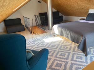 um quarto com uma cama, um sofá e uma cadeira em Namas senamiestyje em Kėdainiai