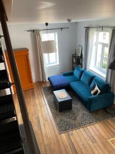 uma sala de estar com um sofá azul e uma mesa em Namas senamiestyje em Kėdainiai