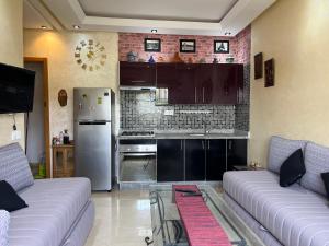 a living room with two couches and a kitchen at Dar laabi in Marrakesh