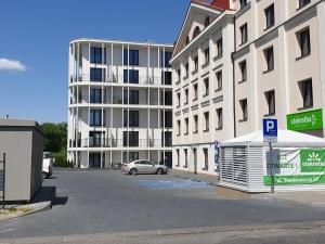 um parque de estacionamento em frente a um grande edifício em Fachpol Apartments Sienkiewicza 22D em Zamość