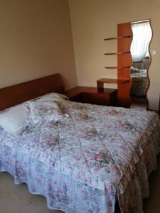1 dormitorio con 1 cama con edredón de flores en Apartamento Combarro, en Combarro