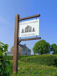 a sign for a holiday cottage in a field at Bwthyn Mair in Llangefni