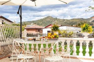 een tafel met stoelen en een fruitschaal op een balkon bij Villa Graziosa in Trappitello