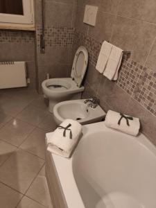 a bathroom with a tub and a toilet with towels at L'appoggio perfetto in Viareggio