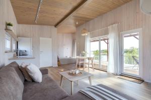 ein Wohnzimmer mit einem Sofa und einem Tisch in der Unterkunft Pineplace twins NIDA in Žaugėdai