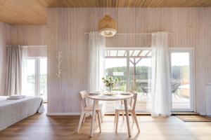 a dining room with a table and chairs and a bedroom at Pineplace twins in Žaugėdai