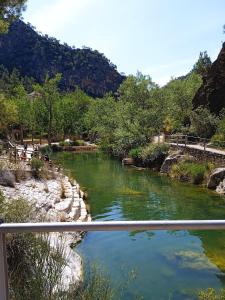 a river next to a bridge with mountains in the background at Casa Mónica in Villalba dels Arcs
