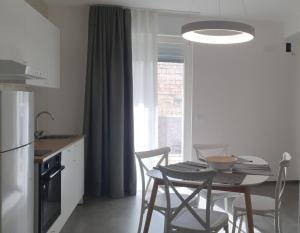 uma cozinha com uma mesa e cadeiras numa cozinha em CASA DI PATTY em Bari Palese
