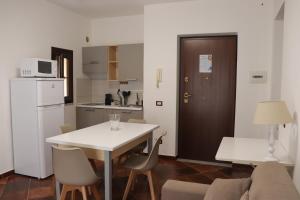パレルモにあるAppartamenti-Residence Al Massimoの小さなキッチン(白いテーブル、椅子付)