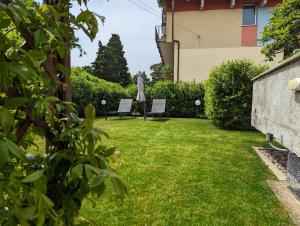 um quintal com duas cadeiras e um guarda-sol em Villa Jasna em Duino