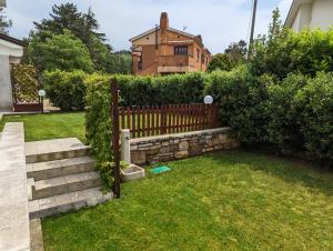 a fence in a yard with a house in the background at Villa Jasna in Duino