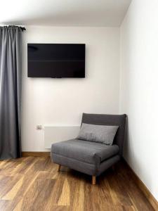 uma sala de estar com uma cadeira e uma televisão de ecrã plano em Green Villa em Saparewo