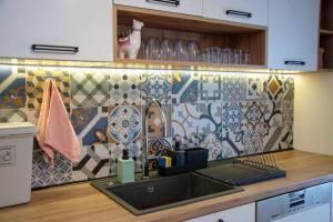 uma cozinha com um lavatório e uma parede de azulejos em Green Villa em Saparewo