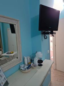 a flat screen tv on a wall with a mirror at B&B Casa Tropea in Tropea