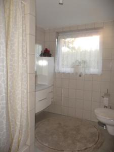 a bathroom with a sink and a toilet and a window at Haus Idylle Weindorf Duchroth - Helle Souterrain Ferienwohnung in Duchroth