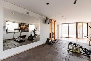 a room with a gym with exercise equipment on the wall at Flat Osasco Trade - Espaço confortável com internet rápida e piscina in Osasco