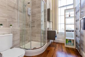a bathroom with a toilet and a glass shower at Newcastle's Most Central Apartment - Sleeps 10 in Newcastle upon Tyne +37 photos