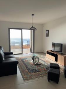 een woonkamer met een bank, een tafel en een televisie bij Appartement 4A villa cargese in Cargèse