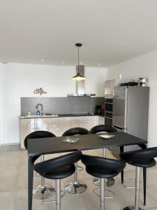 een keuken met een zwarte tafel en zwarte stoelen bij Appartement 4A villa cargese in Cargèse