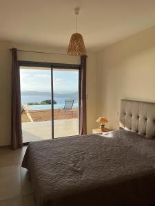 een slaapkamer met een bed en uitzicht op de oceaan bij Appartement 4A villa cargese in Cargèse