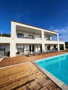 a villa with a swimming pool in front of a house at Appartement 4A villa cargese in Cargèse