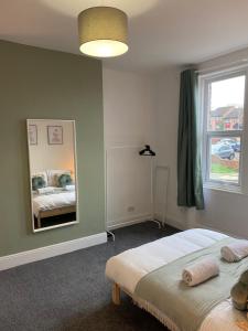 a bedroom with a bed and a large mirror at Overhill 3 bedroom flat 5 beds, free parking, ideal for Contractors in Gateshead