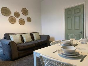 ein Wohnzimmer mit Tisch und Couch in der Unterkunft Overhill 3 bedroom flat 5 beds, free parking, ideal for Contractors in Gateshead