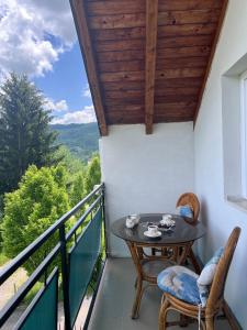 a balcony with a table and chairs and a view at Villa Rose in Sarajevo