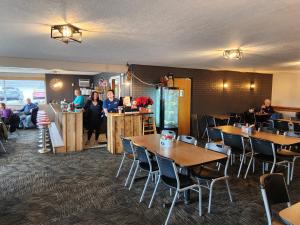 a restaurant with tables and people sitting at a counter at Oak Mar Motel in Oakland