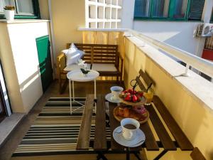 een balkon met een tafel met kopjes en een fruitschaal bij My Splity nest in Split