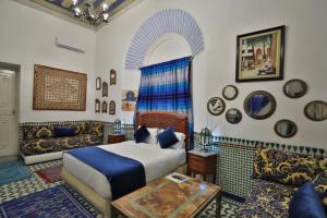a bedroom with a bed and a couch at Studio avec piscine et parking prive in Fès