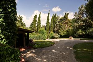 un vialetto in un giardino con alberi e cespugli di Colle Val D'Elsa - Agriturismo Bardeggiano a Colle Val D'Elsa