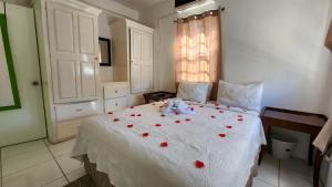 Un dormitorio con una cama con rosas rojas. en Caribbean Dream Vacation Property CD2 en Rodney Bay Village