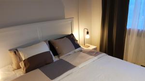 a bedroom with a large white bed with pillows at Błękitny Domek in Wydminy