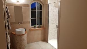 a bathroom with a sink and a shower with a window at Błękitny Domek in Wydminy