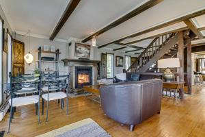 a living room with a table and chairs and a fireplace at Gite le petit Manoir Vue sur rivière St Maurice in Grandes-Piles