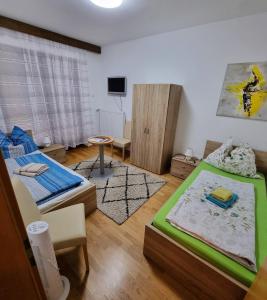 ein Wohnzimmer mit 2 Betten und einem Tisch in der Unterkunft Gästehaus Rettl in Lavamünd