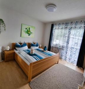 a bedroom with a bed with blue pillows and a window at Gästehaus Rettl in Lavamünd