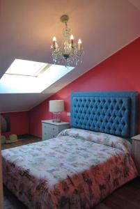 a bedroom with a blue bed and a red wall at La Centralita de la Abuela in Segovia