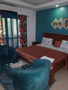 a bedroom with a bed and a couch and a chair at Rincon d'Alicia in Dakar