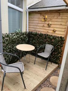 a patio with two chairs and a table and a fence at Pen-Y-Bryn Annex in Brynmenin