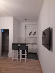 a kitchen with a table and a tv in a room at Anni in Belgrade
