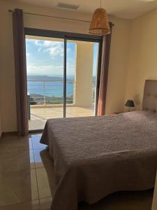 a bedroom with a bed and a view of the ocean at Appartement 140M2 villa cargèse in Cargèse