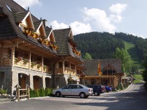 a car parked on the side of a road next to a building at Hotel Nosalowy Dwór in Zakopane